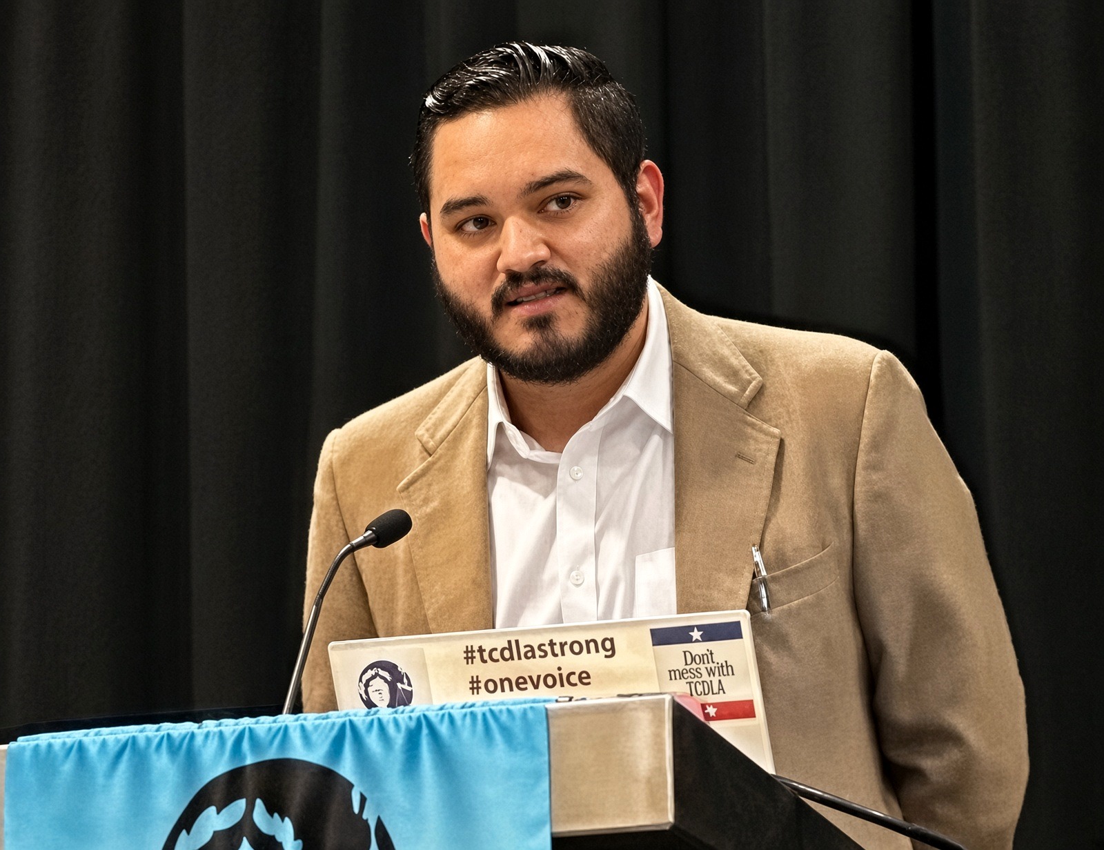 Jacob Vela speaking at a TCDLA podium